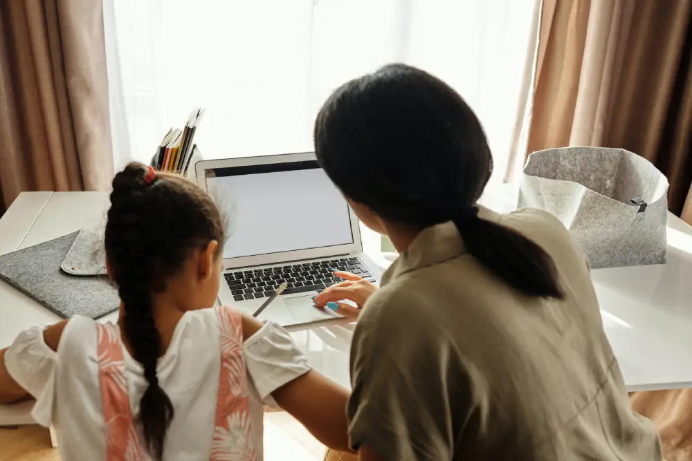 student and teacher infront of laptop